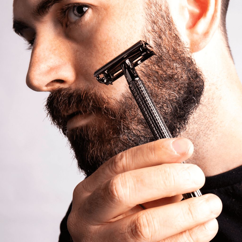 man shaving face with safety razor